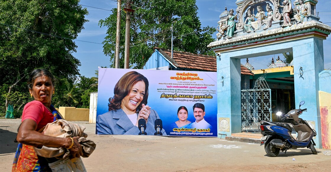 A woman walks past a poster of US Vice President Kamala Harris in her ancestral village of Thulasendrapuram. Photo: Idrees Mohammed/AFP 