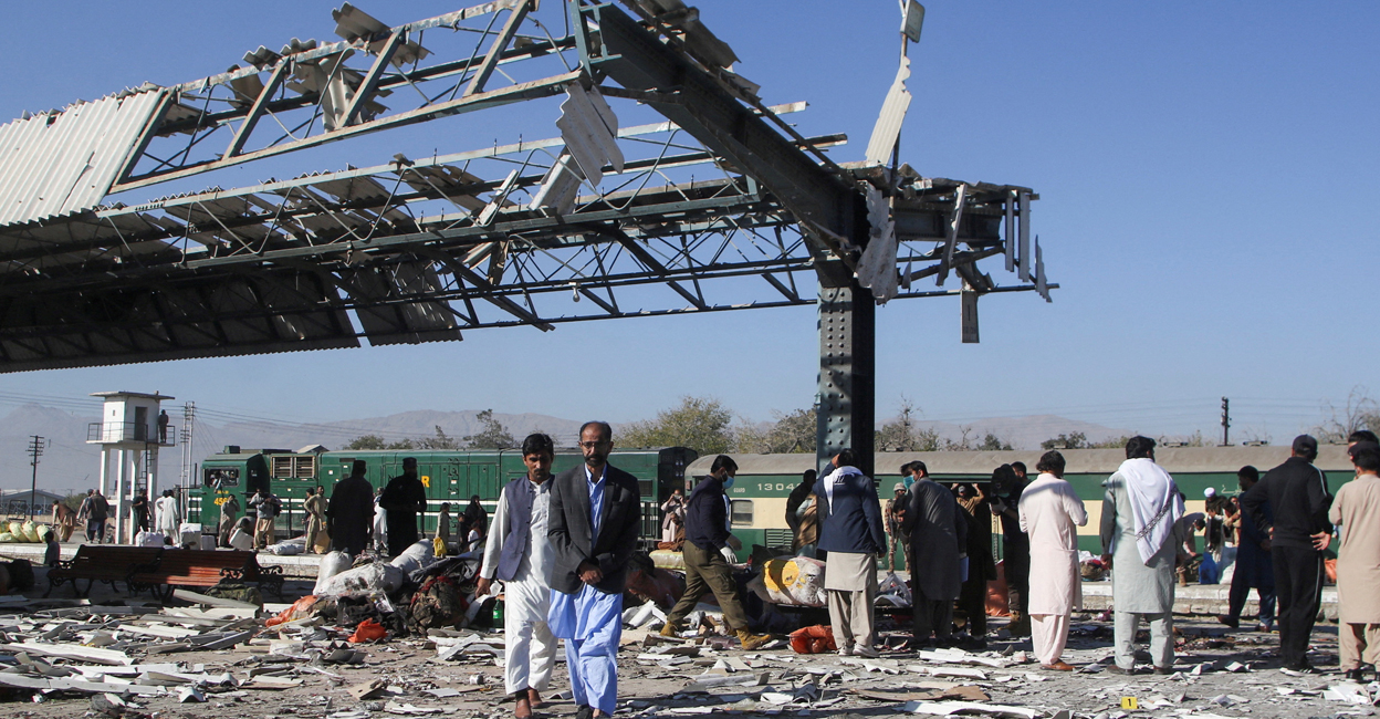 People walk amid the debris after a bomb blast at a railway station in Quetta, Pakistan. Photo: Reuters/Naseer Ahmed