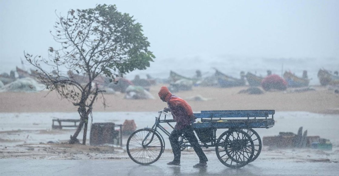 A man pulls his three-wheeler cart amid heavy wind and rainfall at the Marina Beach in Chennai on November 30, 2024, ahead of the landfall of cyclone Fengal in Tamil Nadu. Photo: AFP via PTI. 