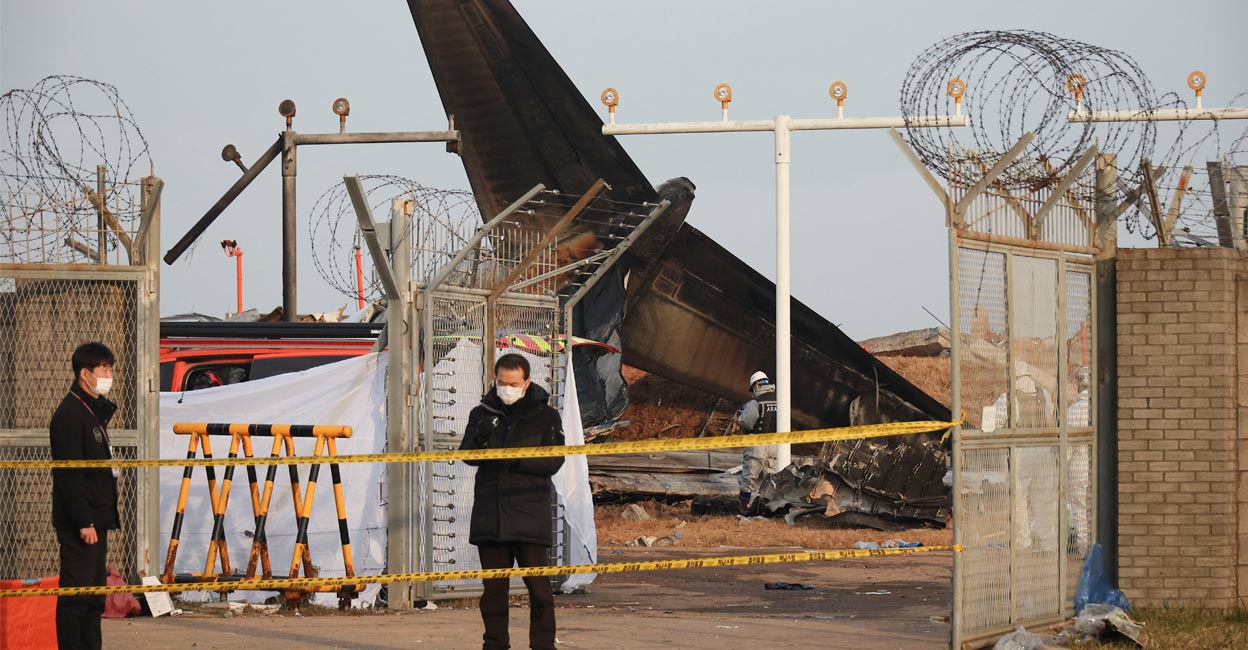 People stand at the site where an aircraft went off the runway and crashed at Muan International Airport, in Muan, South Korea, December 30, 2024. Photo: Reuters. 