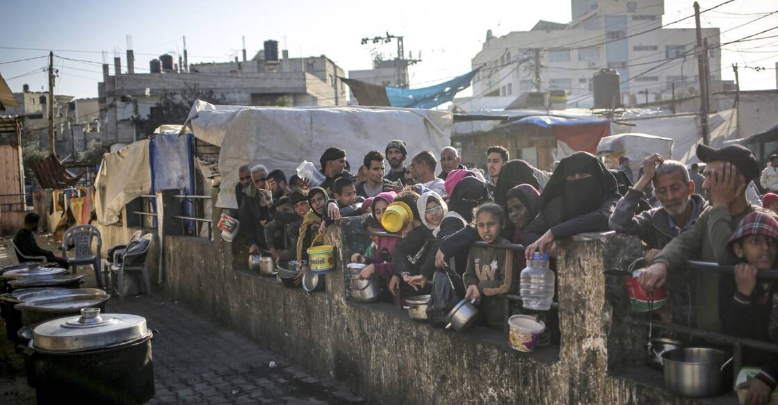 Displaced Palestinians gather to collect food . Photo: AFP