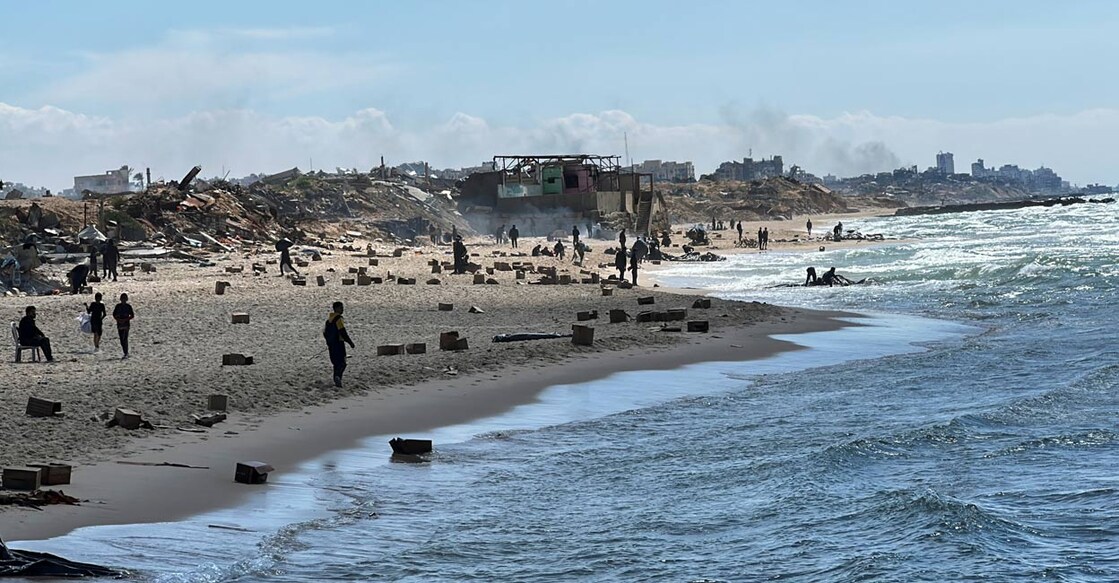 Palestinians gather on a beach as they collect aid airdropped by an airplane, amid the ongoing conflict between Israel and Hamas, in the northern Gaza Strip, March 25, 2024. Photo: Reuters. 