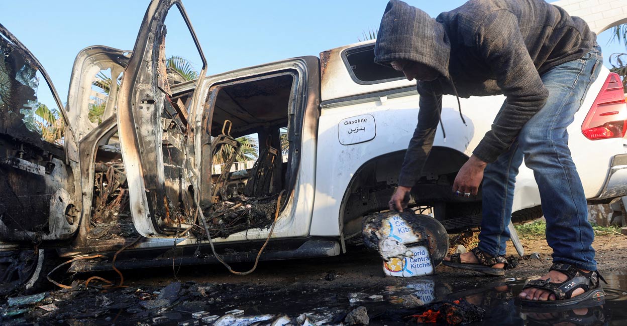 A Palestinian inspects near a vehicle where employees from the World Central Kitchen (WCK) were killed in an Israeli airstrike. Photo: Reuters.