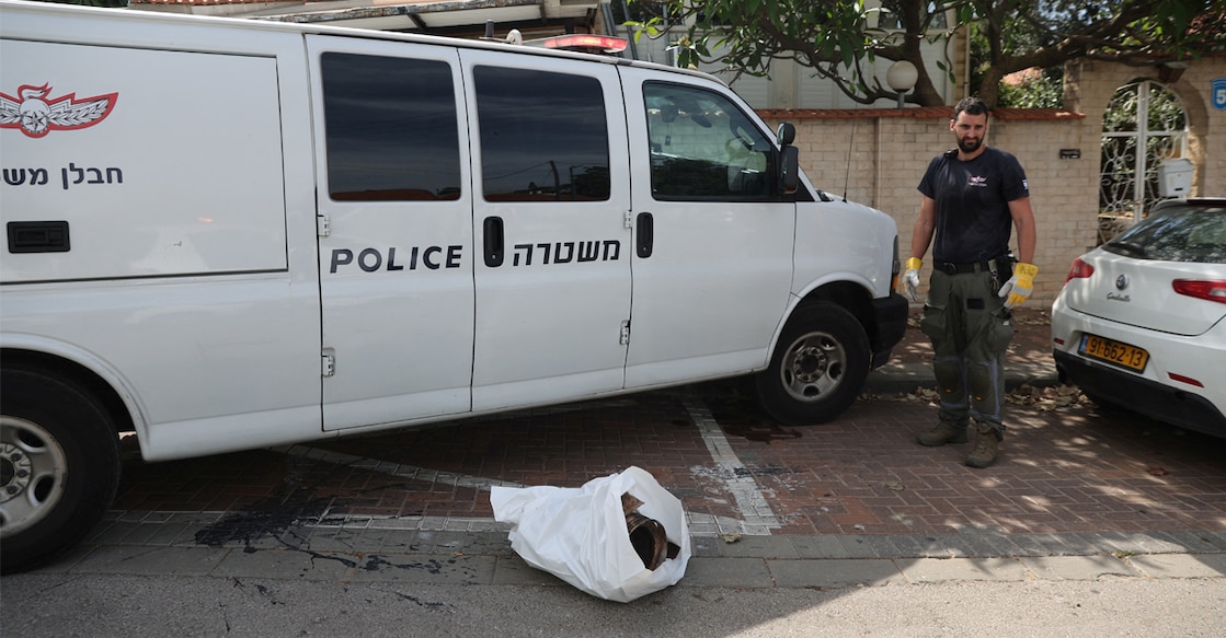 An Israeli police officer stands next to the remains of a rocket after rockets were fired from the Gaza Strip towards Israel. REUTERS/Nir Elias.