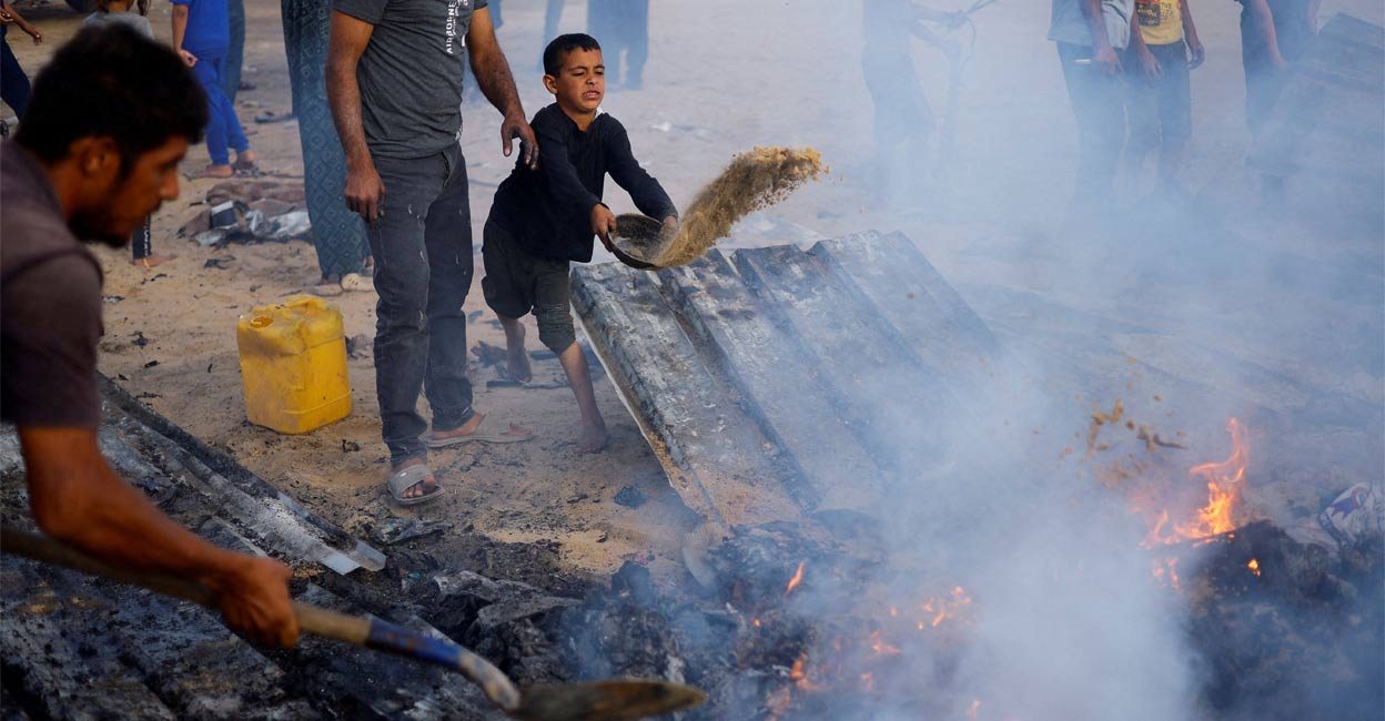 Palestinians put out a fire at the site of an Israeli strike on an area designated for displaced people, in Rafah, in the southern Gaza Strip, May 27, 2024. File Photo: Reuters. 