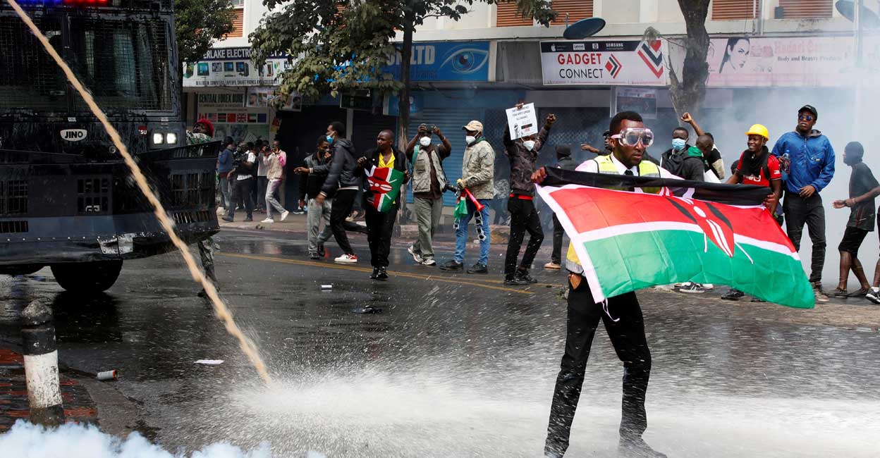 KENYA-BUDGET A demonstrator holds a Kenyan flag as police use water cannons and tear gas to disperse protesters during a demonstration against Kenya's proposed finance bill 2024/2025 in Nairobi, Kenya, June 25, 2024. Reuters/Monicah Mwangi