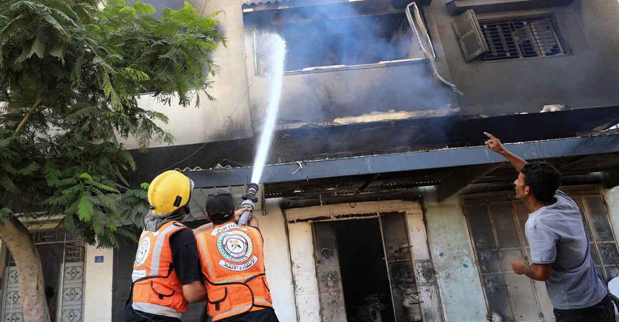 ISRAEL-PALESTINIANS Members of the Civil Defence work to extinguish fire, after Israeli forces withdrew from a part of Gaza City, following a ground operation, amid the Israel-Hamas conflict, in Gaza City, July 12, 2024. REUTERS/Dawoud Abu Alkas