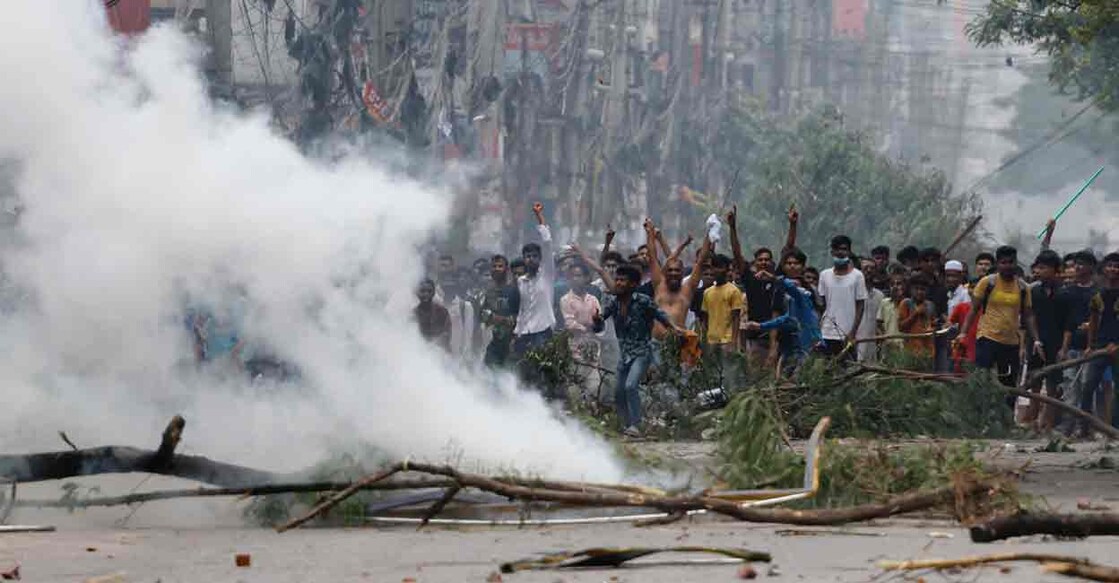 People gesture near smoke as protesters clash with Border Guard Bangladesh (BGB) and the police outside the state-owned Bangladesh Television as violence erupts across the country after anti-quota protests by students, in Dhaka, Bangladesh, July 19, 2024. Photo: REUTERS/Mohammad Ponir Hossain