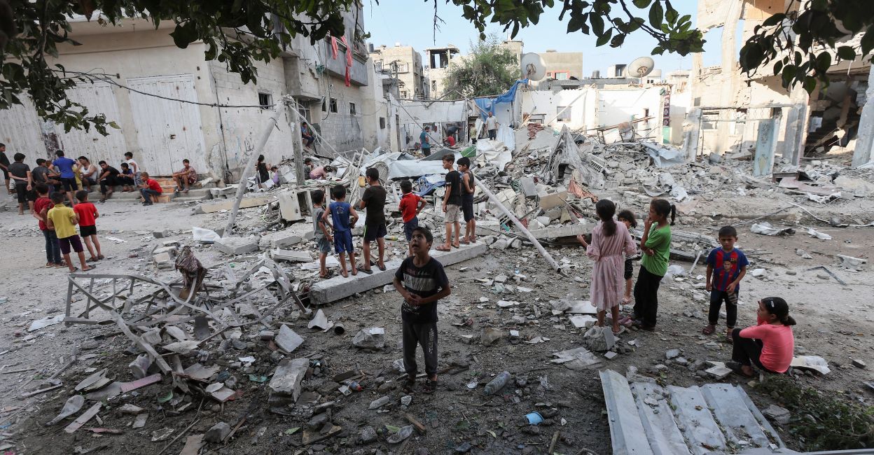 Palestinian children stand at the site of an Israeli strike on a house, amid the Israel-Hamas conflict, in Maghazi refugee camp in the central Gaza Strip, August 14, 2024. Photo: Reuters/Ramadan Abed