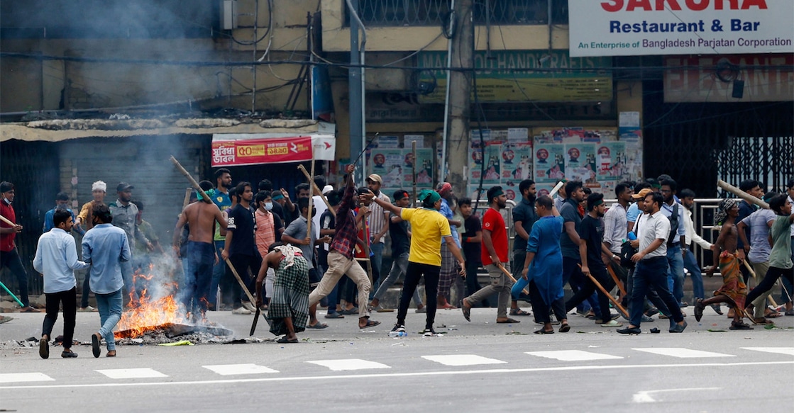 Objects set on fire burn as demonstartors with sticks occupy the street during a protest demanding the stepping down of Bangladesh PM. Image: REUTERS/Mohammad Ponir Hossain