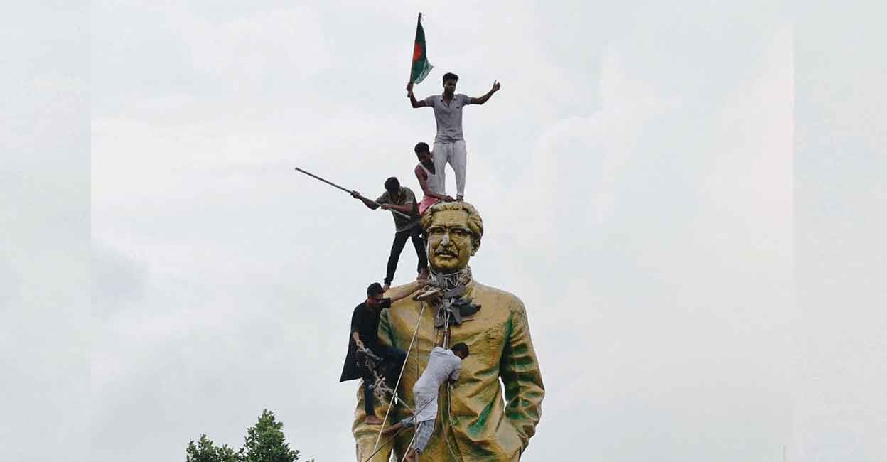 mujibur-rahman-statue-vandalised People climb the statue of Sheikh Mujibur Rahman at the Bijoy Sarani area, as they celebrate the resignation of the Prime Minister Sheikh Hasina in Dhaka, Bangladesh, August 5, 2024. Photo: Reuters/Mohammad Ponir Hossain