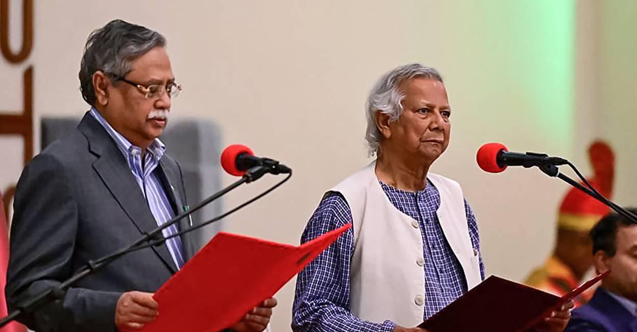 Nobel laureate Muhammad Yunus (C) takes the oath of office as the chief adviser of Bangladesh's new interim government during the oath-taking ceremony administered by President Mohammed Shahabuddin (L) in Dhaka. Photo: AFP