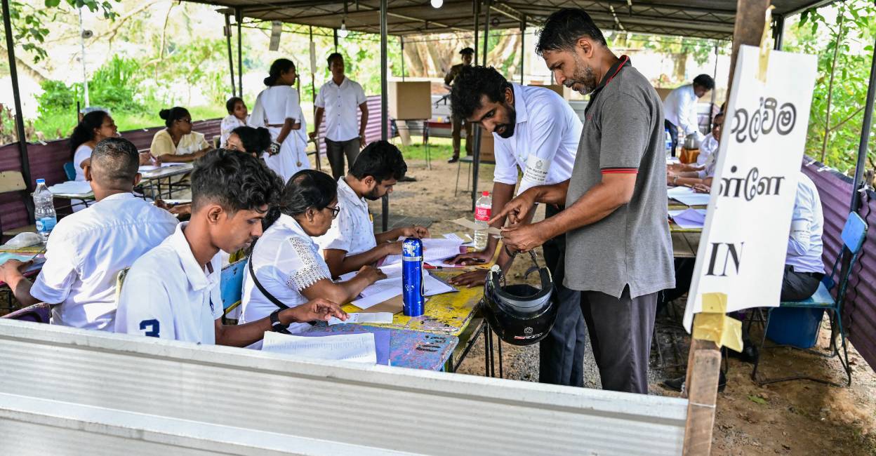 srilanka-polls Officials check documents of a voter as he arrives to cast his ballot at a polling station during voting in Sri Lanka's presidential election in Colombo . Photo: AFP