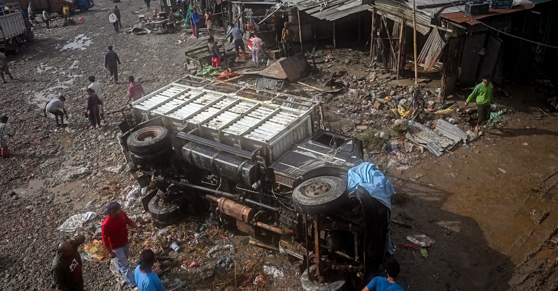 A damaged vehicle is seen amid mud and debris in a flood-affected area. Photo: PRAKASH MATHEMA/AFP