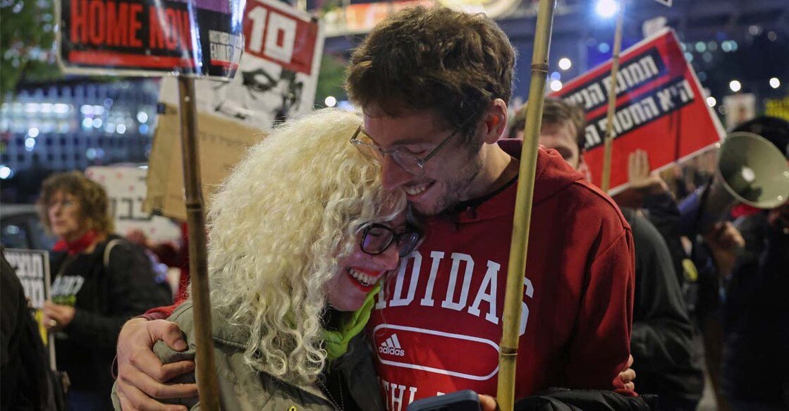 Demonstrators embrace each other during a protest in front of the Israeli defence ministry in Tel Aviv. Photo: AFP