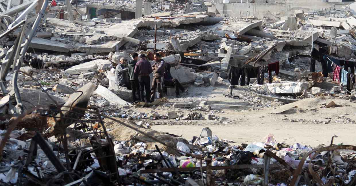 Palestinians stand among the rubble of houses destroyed in previous Israeli strikes, amid ceasefire negotiations with Israel, in Gaza City, January 15, 2025. REUTERS/Mahmoud Issa