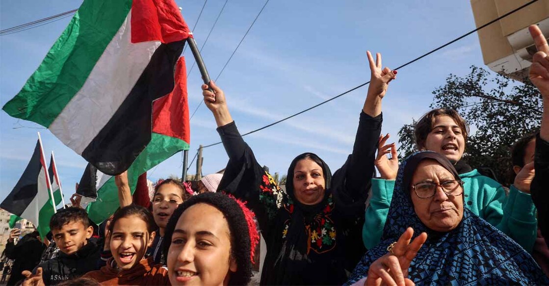 Displaced Palestinians waving national flags cheer as they return to Rafah in the southern Gaza Strip on January 19, 2025. Photo: Eyad BABA/AFP