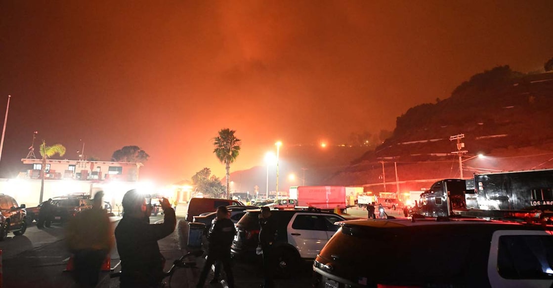 People take photos of the Palisades Fire from Will Rogers State Beach in the Pacific Palisades neighbourhood of Los Angeles, California. Photo: AFP