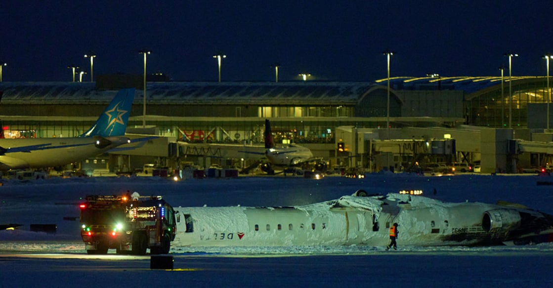 A Delta plane sits on its roof after crash landing. Photo: AFP