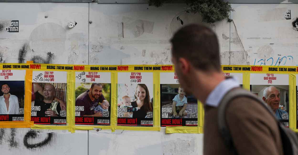 ISRAEL-PALESTINIANS-HOSTAGES A man walks past pictures of Yarden Bibas, Shiri Bibas and Kfir Bibas, who were kidnapped during the deadly October 7, 2023 attack on Israel, in Jerusalem, February 19, 2025. Photo: REUTERS/Ronen Zvulun