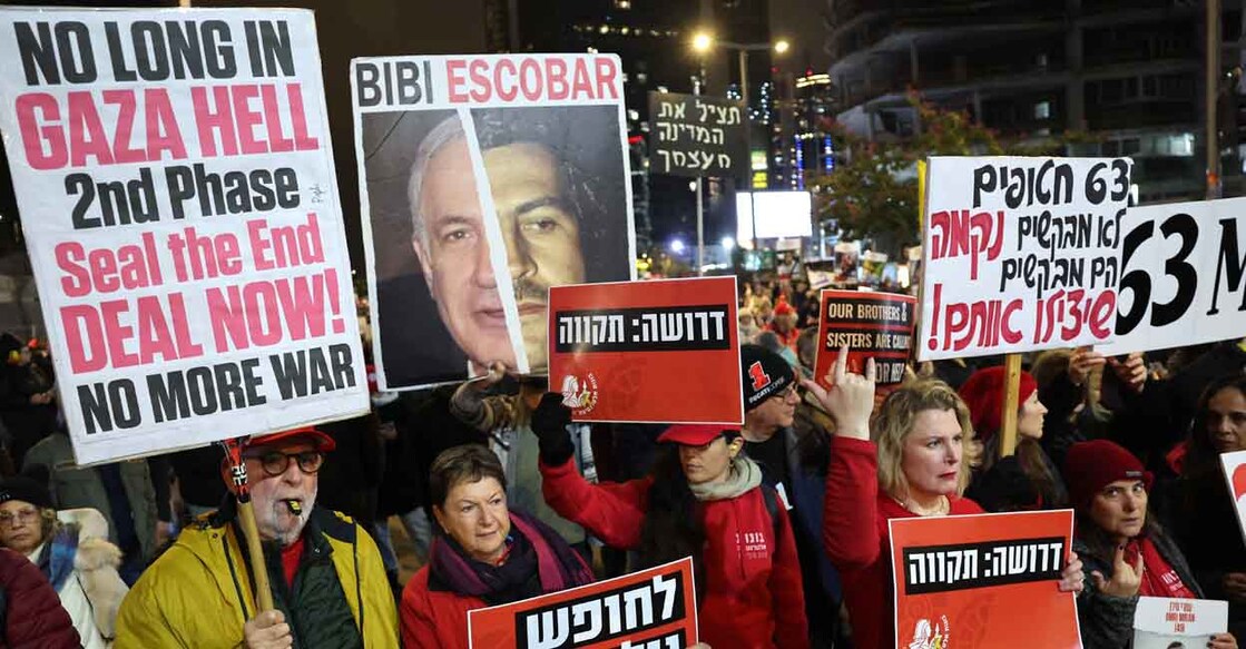Demonstrators raise placards and chant slogans during a protest calling for the release of hostages held captive in Gaza since the October 7, 2024 attack by Palestinian militants, in front of the Israeli Defence Ministry in Tel Aviv on February 22, 2025. (Photo by Jack GUEZ / AFP)