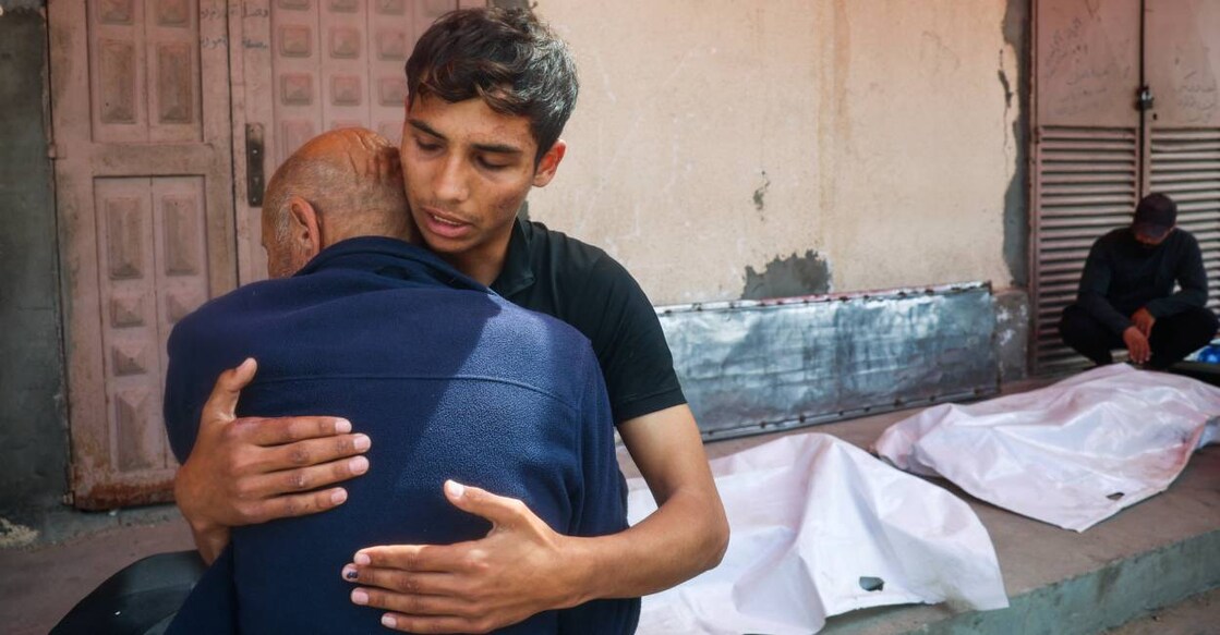 Relatives mourn by the bodies of three Palestinian men who were killed in an Israeli drone strike east of the Bureij camp, at the al-Aqsa Martyrs hospital in Deir el-Balah in the central Gaza Strip. Photo: AFP