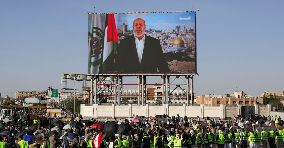 hamas Protesters, mainly Houthi supporters, stand near a screen displaying Senior Hamas official Khalil al-Hayya. File Photo: Reuters