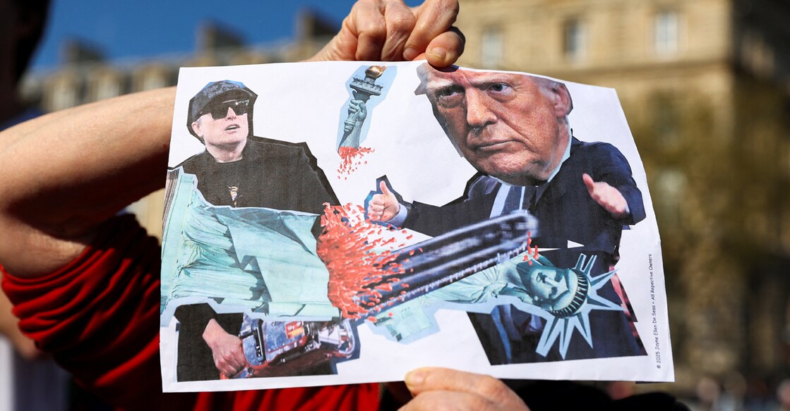 A person holds a placard as people attend 'Hands Off!' demonstration against U.S. President Donald Trump and his adviser Elon Musk as part of an anti-Trump and anti-Tesla worldwide movement, at Place de la Republique in Paris, France. Photo: REUTERS/Abdul Saboor