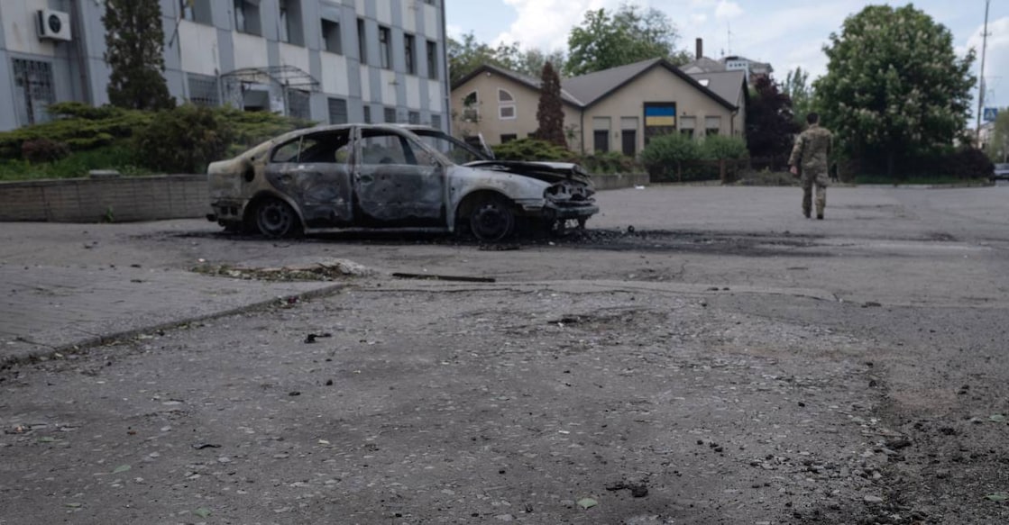 This handout photograph taken on May 16, 2025 and released on May 17, 2025 by the press service of the 93rd Kholodnyi Yar Separate Mechanized Brigade of the Ukrainian Ground Forces shows a crater next to a burnt car with the body of a killed person inside following a drone attack. Photo: AFP