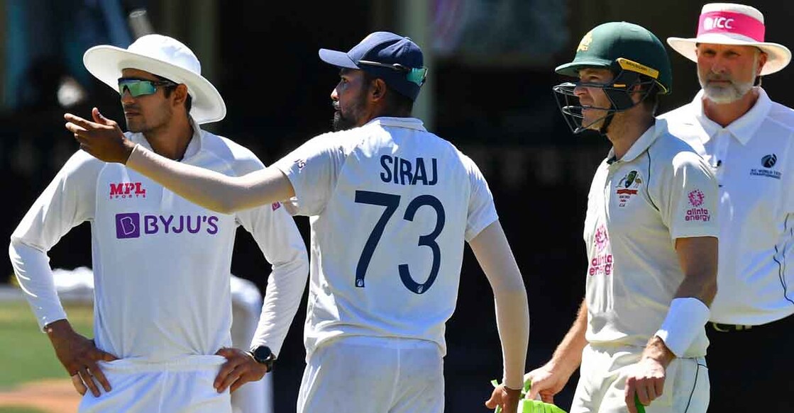Mohammed Siraj gestures next to Australia's captain Tim Paine as the game was halted during the fourth day of the Sydney Test. Photo: AFP