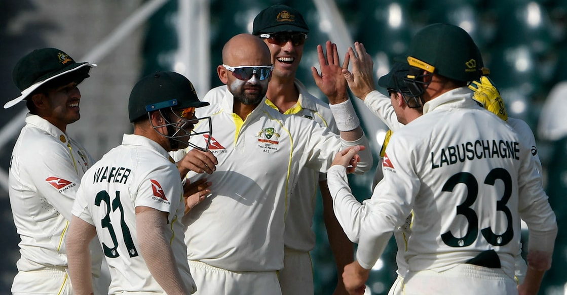 Australia's Nathan Lyon, third left, celebrates with teammates after taking the wicket of Hasan Ali. Photo: AFP/Aamir Qureshi