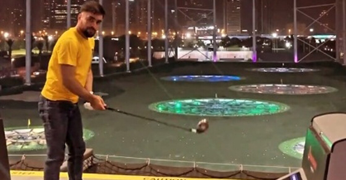 Rashid Khan replicates the 'snake the shot' with a golf club. Photo: IANS