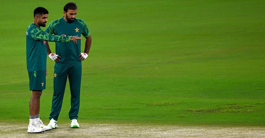Pakistan captain Babar Azam, left, and teammate Iftikhar Ahmed inspect the pitch. Photo: AFP/Punit Paranjpe