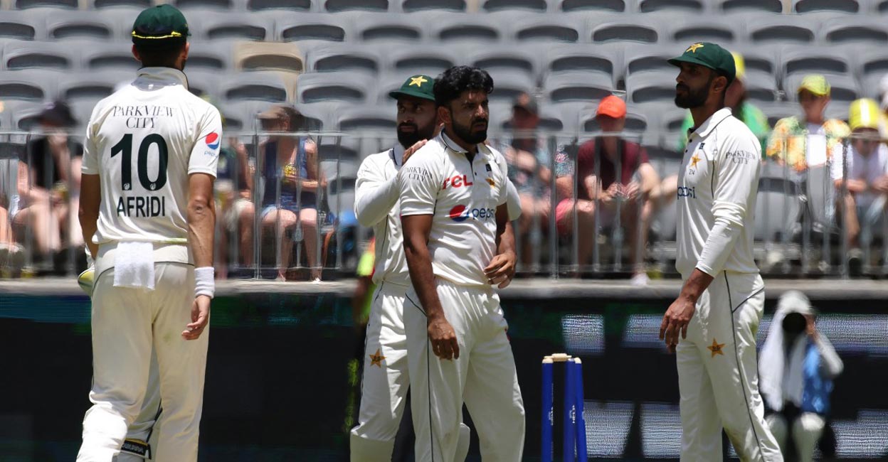 Aamir Jamal is congratulated by teammates on taking the wicket of Mitchell Starc. Photo: AFP/Colin Murty