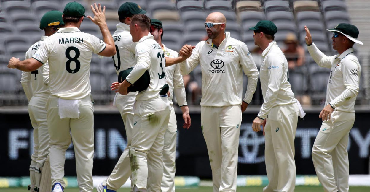 Nathan Lyon, third right, celebrates with teammates after dismissing Imam-ul-Haq. Photo: AFP/Colin Murty