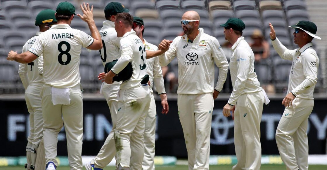 Nathan Lyon, third right, celebrates with teammates after dismissing Imam-ul-Haq. Photo: AFP/Colin Murty