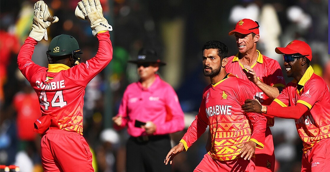 Sikandar Raza celebrates a West Indies wicket with his teammates. Photo: IANS