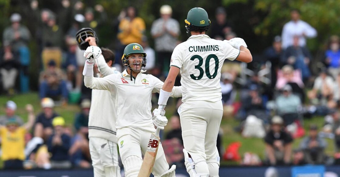 Australia's Pat Cummins and Alex Carey celebrate their victory on day four of the second Test cricket match with New Zealand. Photo: Sanka Vidanagama / AFP