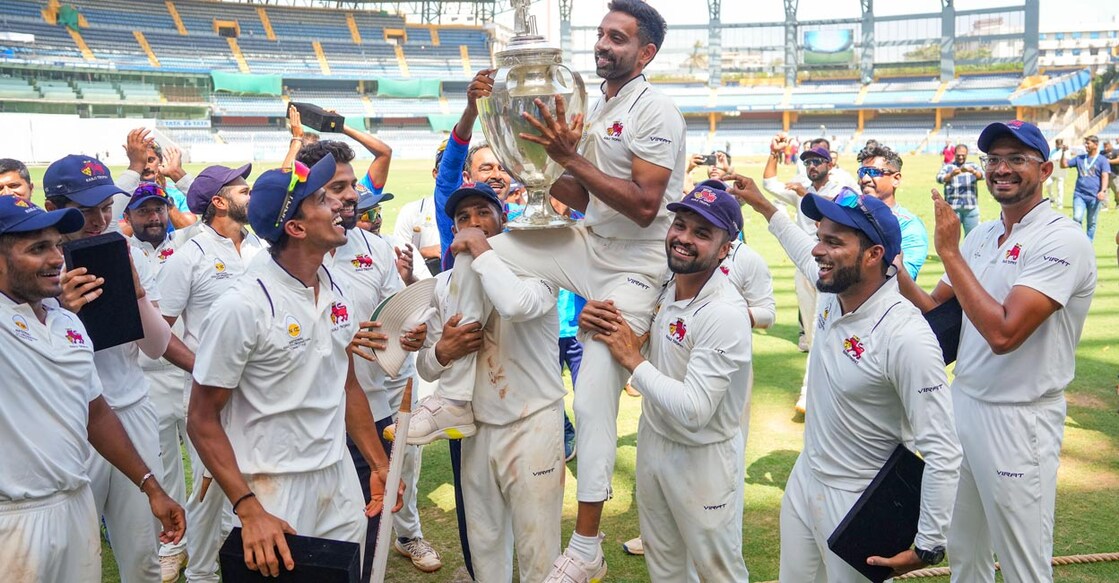 Dhawal Kulkarni holds the Ranji Trophy and celebrates with Mumbai teammates. Photo: PTI/Shashank Parade