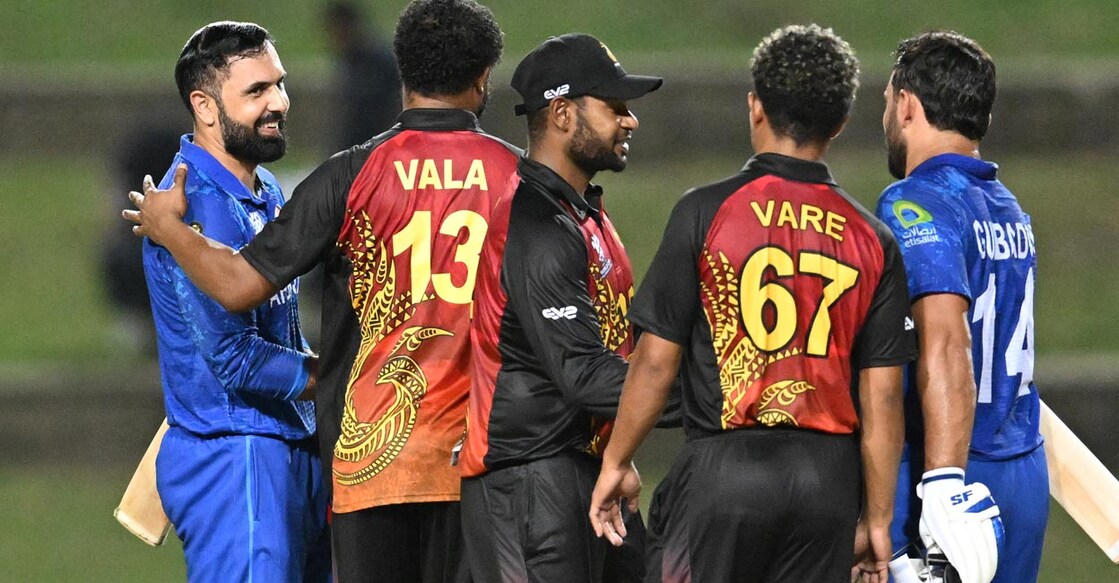 Afghanistan's Mohammad Nabi, left,  Gulbadin Naib, right, grret the Papua New Guinea players after the game. Photo: AFP/Marco Bello