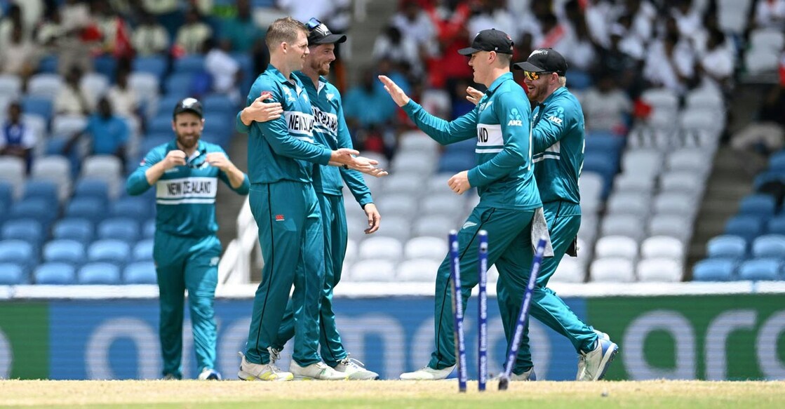 New Zealand players congratulate Lockie Ferguson on picking up a wicket. Photo: AFP/Marco Bello