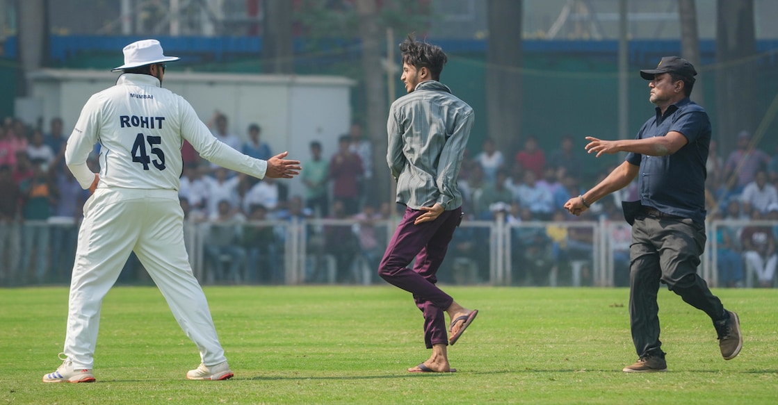 A pitch invader goes after Mumbai's Rohit Sharma on the third day of a Ranji Trophy match against Jammu and Kashmir at Sharad Pawar Cricket Academy BKC in Mumbai on Saturday. Photo: PTI