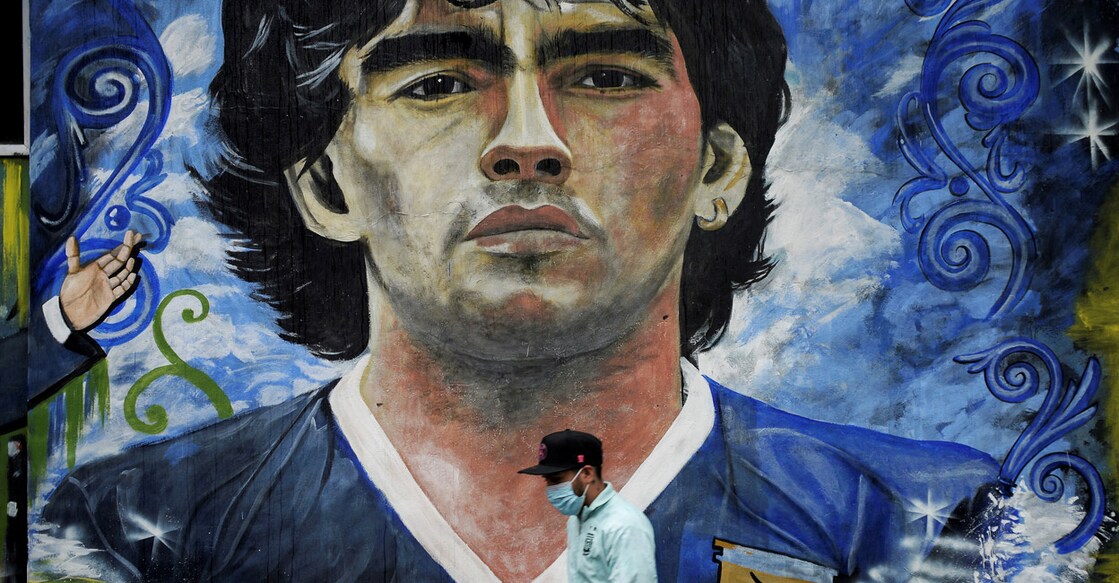 A pedestrian walks past a mural depicting late soccer legend Diego Maradona in La Boca, Buenos Aires, on Thursday. Photo: Reuters/Mariana Nedelcu
