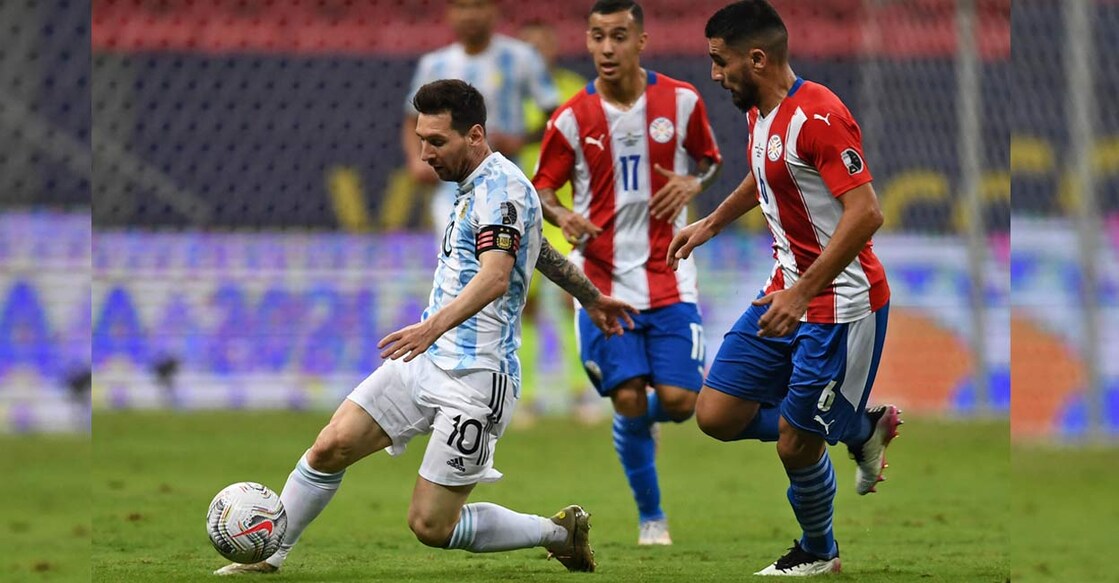 Argentina's Lionel Messi (L) and Paraguay's Junior Alonso vie for the ball during their Conmebol Copa America 2021 football tournament group phase match at the Mane Garrincha Stadium. Photo: AFP