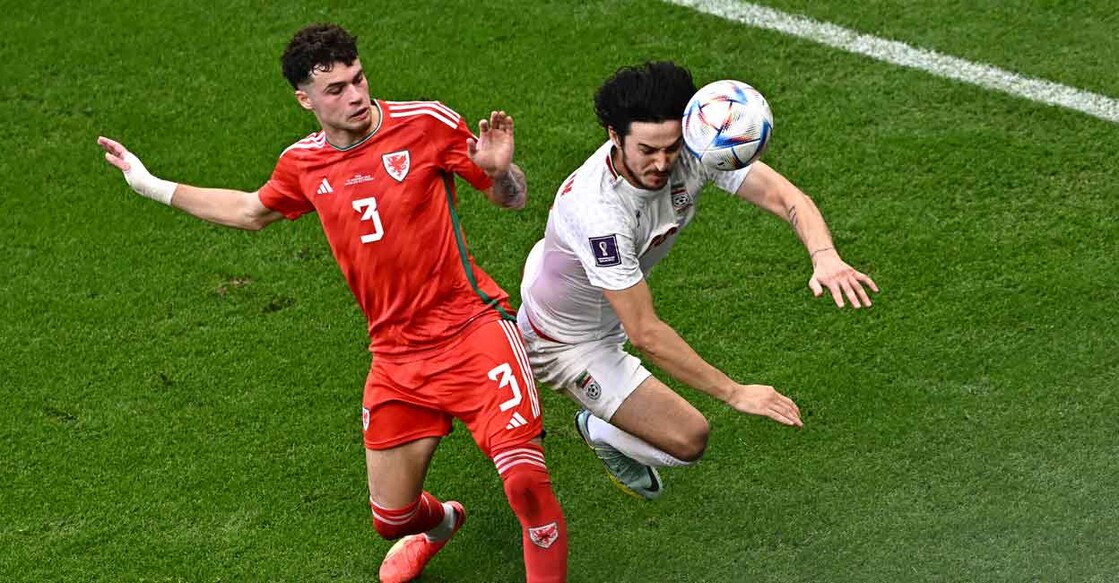 Iran's Sardar Azmoun fights for the ball with Wales' Neco Williams. AFP/Anne-Christine Poujoulat