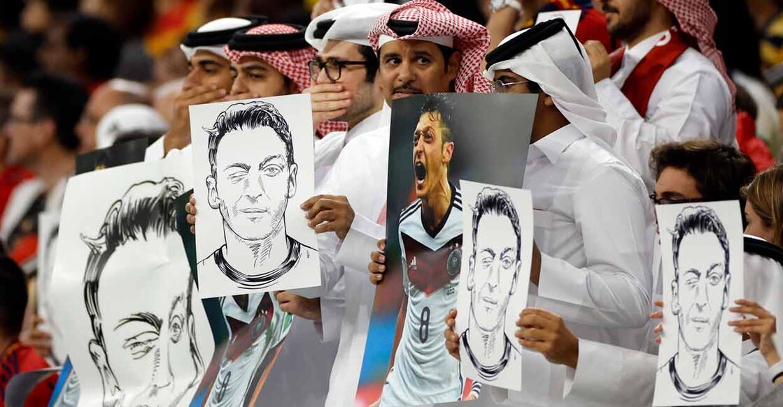 Qatari fans hold up signs displaying former Germany player Mesut Ozil in the stands. Photo: Reuters/John Sibley