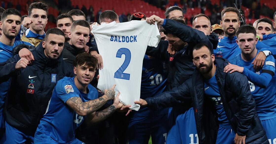 Greek players hold up a shirt in a tribute to George Baldock after the win. Photo: Action Images via Reuters/Paul Childs