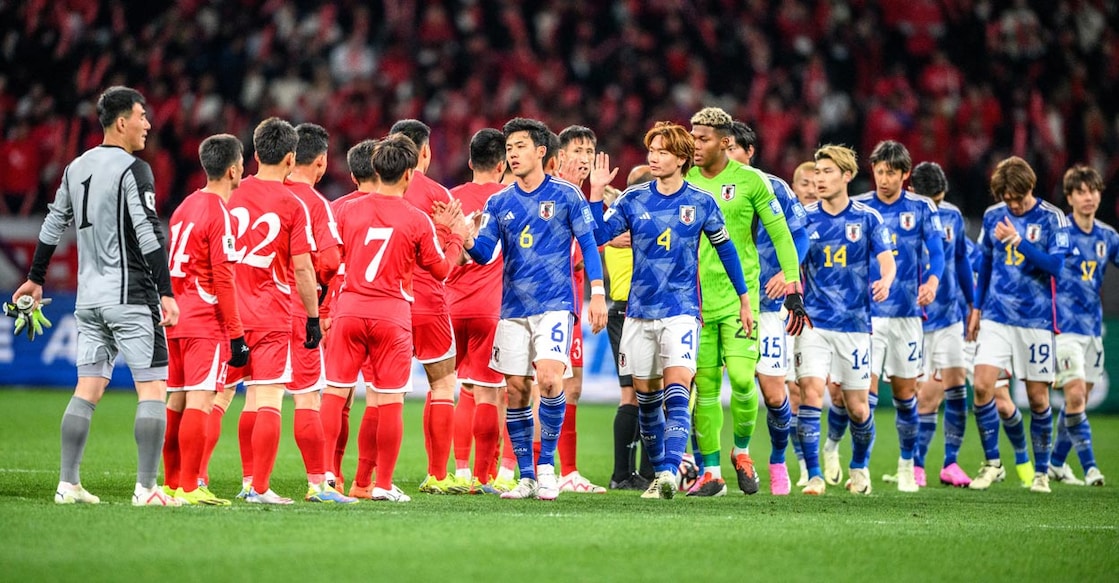 Japanese, blue jersey, and North Korean players greet each other after their World Cup qualifier in Tokyo on Thursday. Photo: AFP/Philip Fong 
