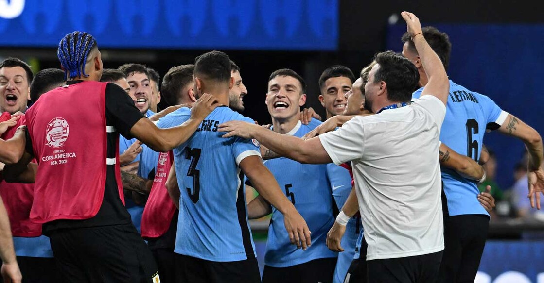 Uruguay's midfielder #05 Manuel Ugarte (C) celebrates with teammates after scoring in a penalty shoot-out to win the Conmebol 2024 Copa America tournament quarter-final football match between Uruguay and Brazil at Allegiant Stadium in Las Vegas, Nevada on July 6, 2024. (Photo by Robyn BECK / AFP)
