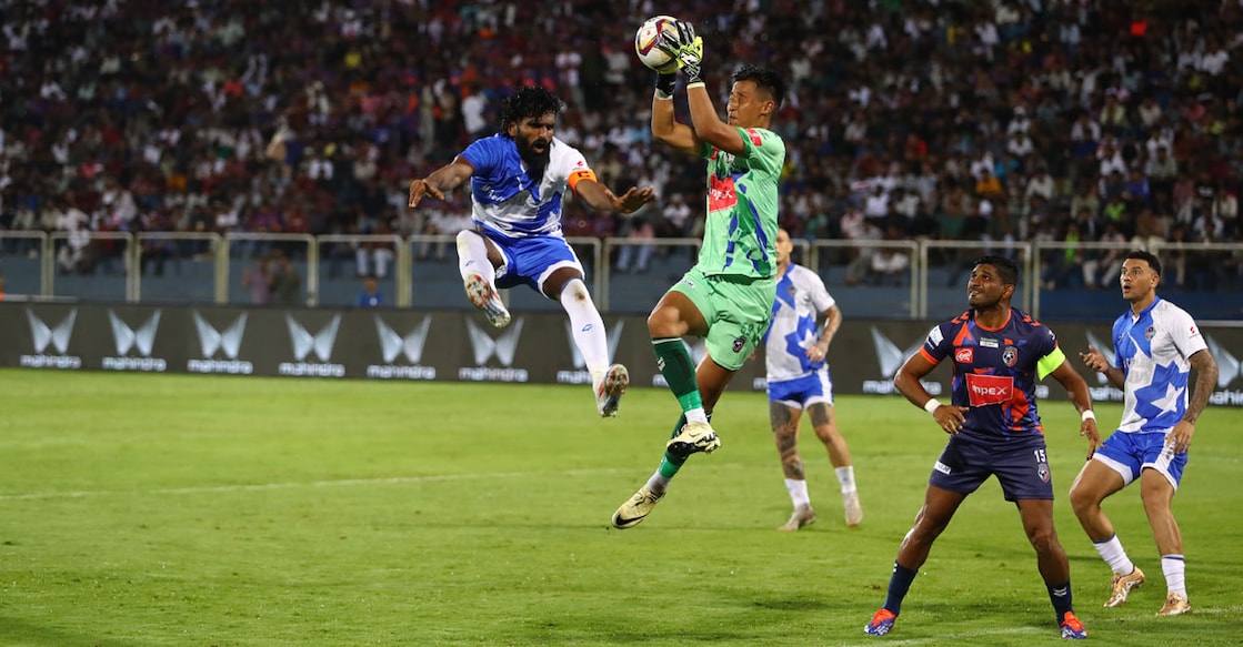 thrissur-magic-vs-malappuram Goalkeeper Tenzin Samdup collects the ball, under pressure from CK Vineeth, captain of Thrissur Magic, during a Super League Kerala match at the Payyanad Stadium in Manjeri on Friday. Malappuram captain Anas Edathodika looks on. Photo: Special arrangement